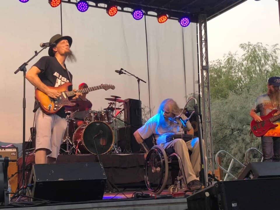 Picture taken from the crowd capturing Johnny Wheels & The Swamp Donkeys on stage at a music festival.