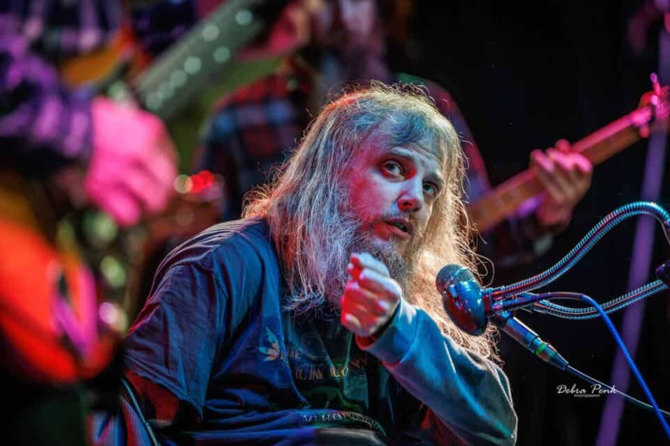 On stage: Johnny Wheels on stage motioning to Brandon Logan (Guitar Player) during a song.