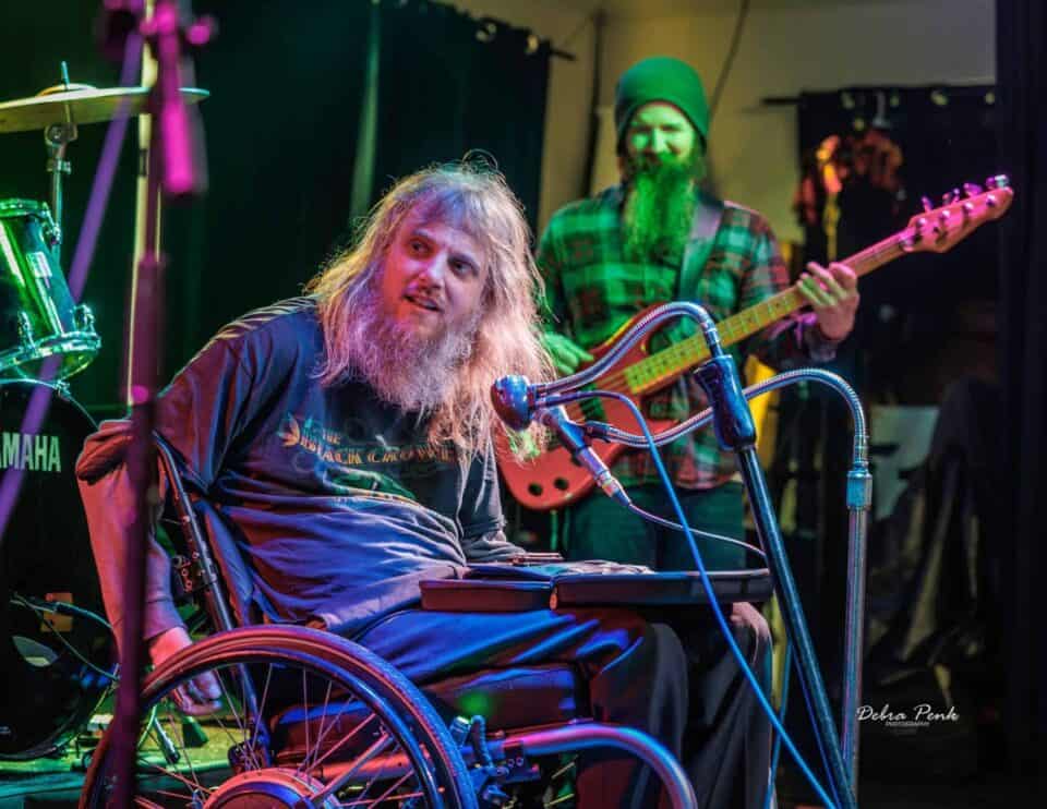 Johnny Wheels on stage between songs with bass player Taylor Frazier in the background.