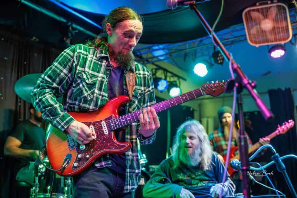 Brandon Logon shreddin' on the guitar with Johnny, Taylor (bass) and Shook Black (drums) in the background.